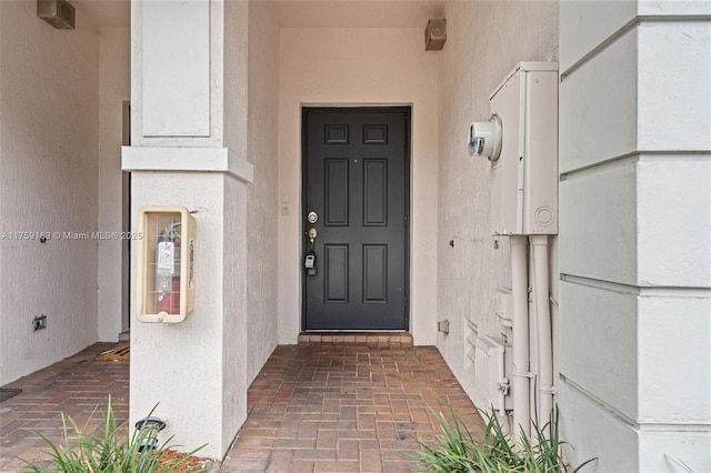 view of exterior entry featuring stucco siding