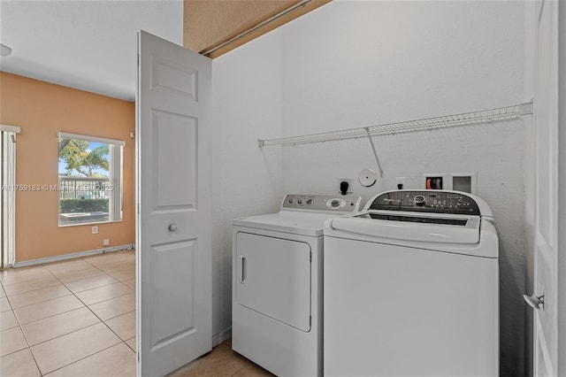 clothes washing area with light tile patterned floors, laundry area, and washer and dryer