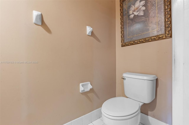 bathroom with tile patterned floors, toilet, and baseboards