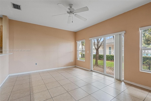 spare room featuring light tile patterned floors, baseboards, visible vents, and ceiling fan