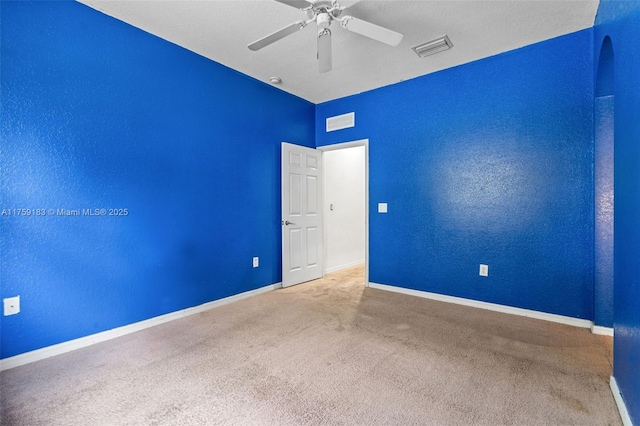 empty room with carpet flooring, baseboards, visible vents, and ceiling fan