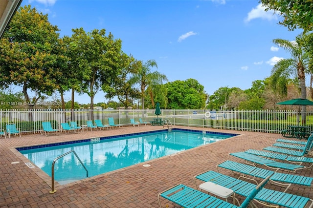 pool with a patio and fence