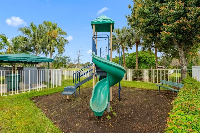 community jungle gym featuring a lawn and fence