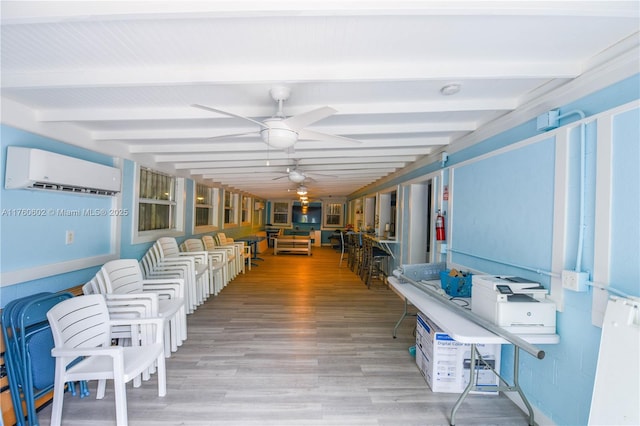 sunroom / solarium featuring a wall unit AC, a ceiling fan, and beam ceiling