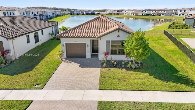 mediterranean / spanish-style house featuring a residential view, a tile roof, and a water view