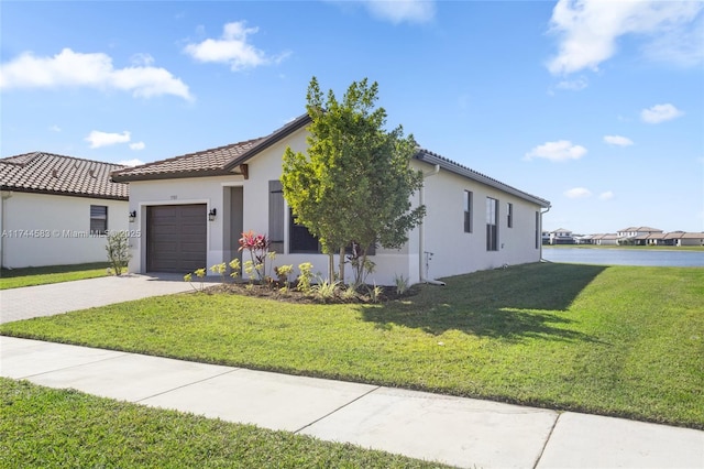 view of front facade featuring a front lawn, a garage, driveway, and stucco siding