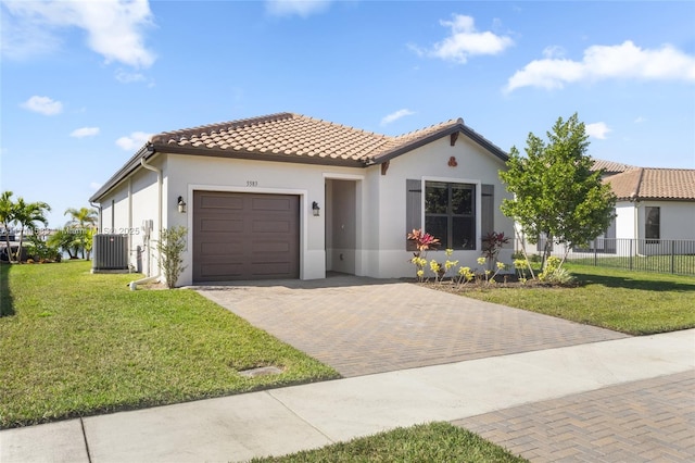 mediterranean / spanish-style house with stucco siding, a front lawn, a tile roof, decorative driveway, and an attached garage