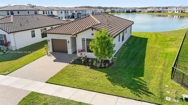 view of front facade with decorative driveway, a residential view, a front lawn, and an attached garage