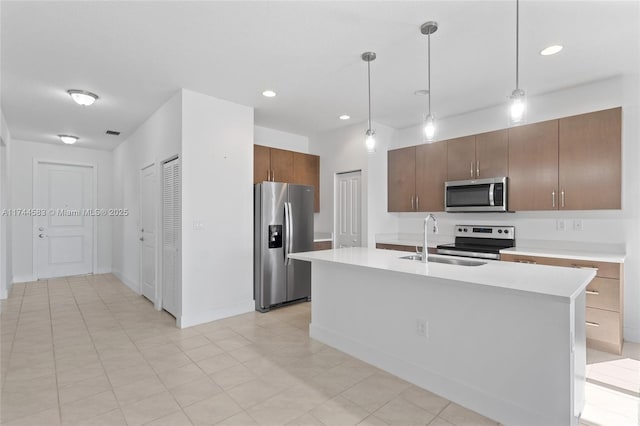 kitchen featuring visible vents, decorative light fixtures, light countertops, stainless steel appliances, and a sink