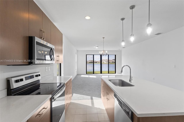 kitchen featuring visible vents, a sink, open floor plan, appliances with stainless steel finishes, and light colored carpet