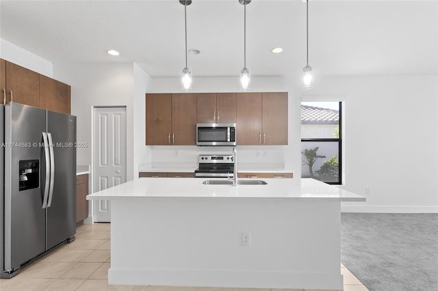 kitchen with decorative light fixtures, stainless steel appliances, light tile patterned flooring, and light countertops