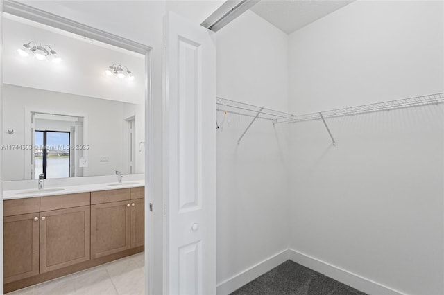 walk in closet featuring light tile patterned floors and a sink