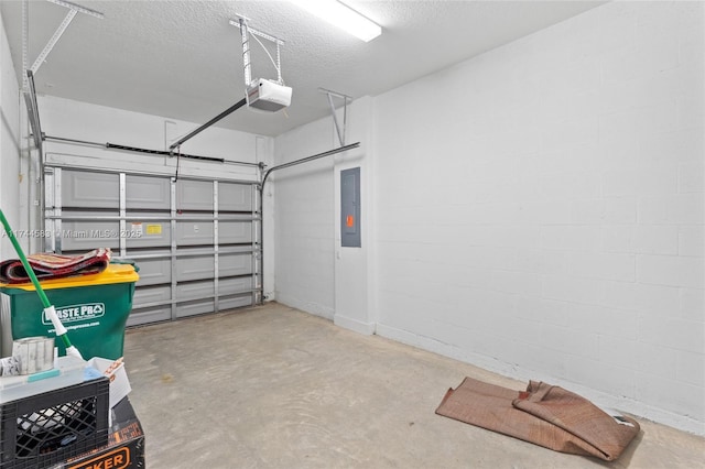 garage with electric panel, a garage door opener, and concrete block wall