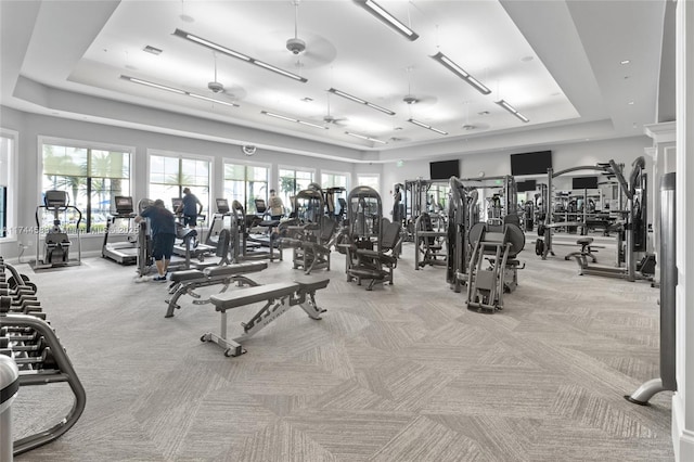 gym with a tray ceiling, carpet, and visible vents