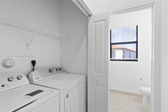 laundry area featuring light tile patterned floors, laundry area, and washer and clothes dryer