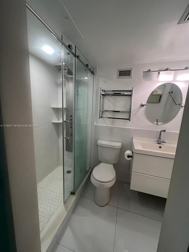 bathroom with visible vents, a shower stall, toilet, and vanity