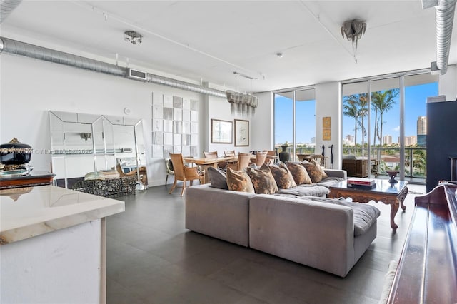 living room featuring visible vents, a city view, baseboards, and expansive windows