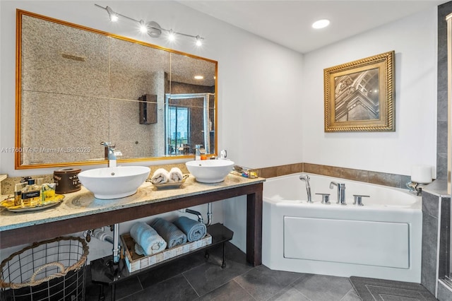 bathroom with a sink, a stall shower, a bath, and double vanity