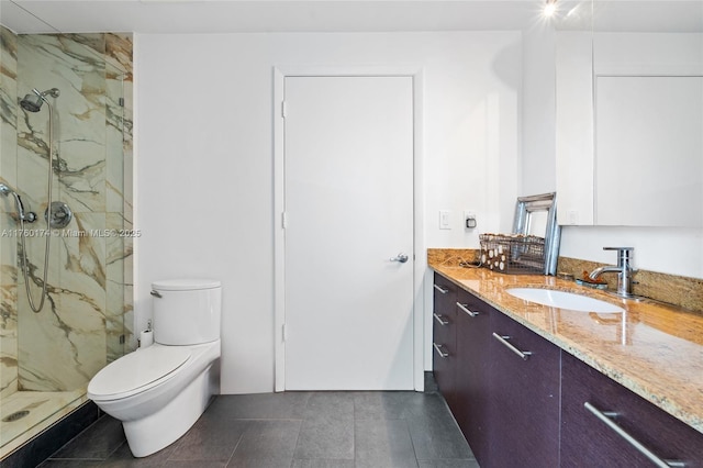 bathroom featuring a marble finish shower, toilet, and vanity