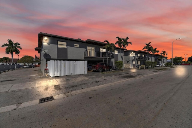 property at dusk featuring fence