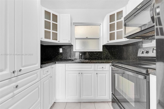 kitchen with black appliances, white cabinets, tasteful backsplash, and a sink