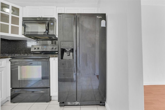 kitchen with black appliances, backsplash, dark countertops, white cabinets, and glass insert cabinets