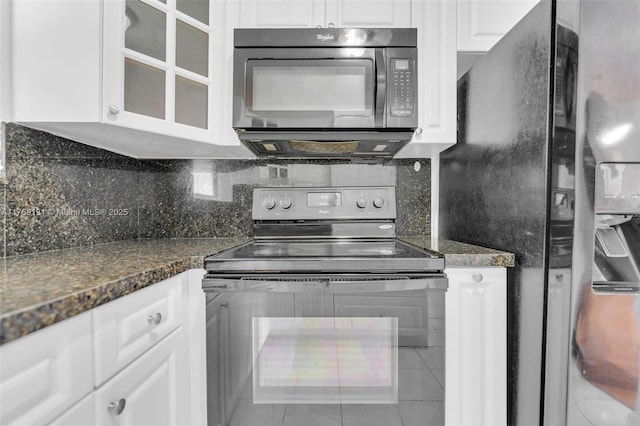 kitchen with white cabinetry, black appliances, glass insert cabinets, and backsplash