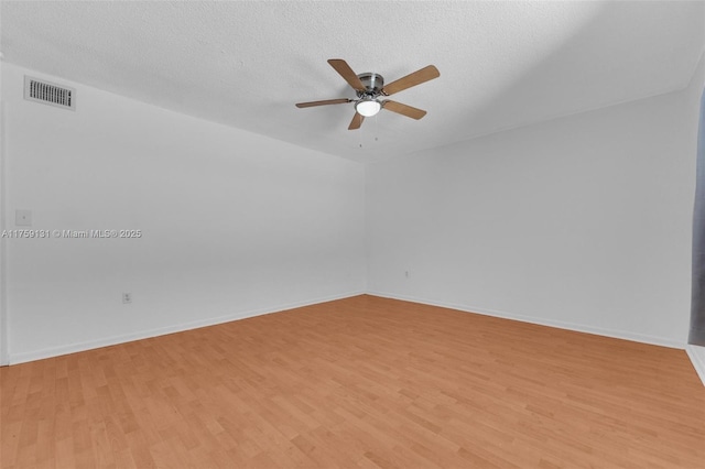 unfurnished room with visible vents, a textured ceiling, and light wood-style flooring