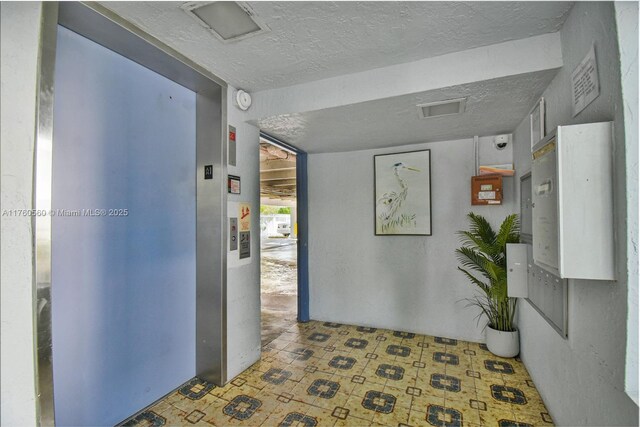 618 Euclid Ave Unit 303, Miami Beach, FL 33139 - hall with elevator, a textured ceiling, and tile patterned floors