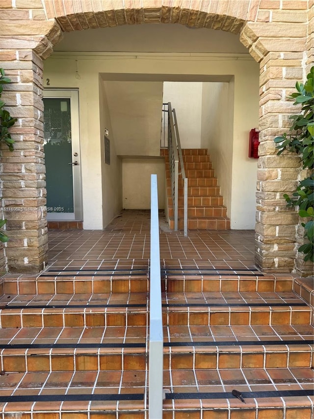 view of exterior entry with brick siding and stucco siding