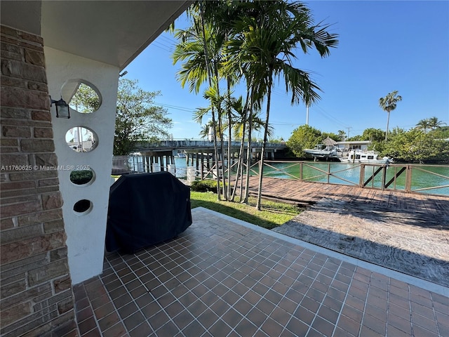 exterior space featuring a gate, grilling area, and a water view