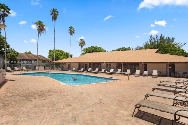 community pool with a patio area and fence