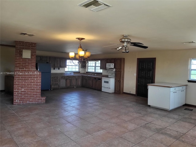 kitchen featuring visible vents, white appliances, and baseboards