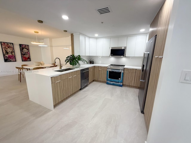 kitchen featuring visible vents, stainless steel appliances, modern cabinets, and a sink