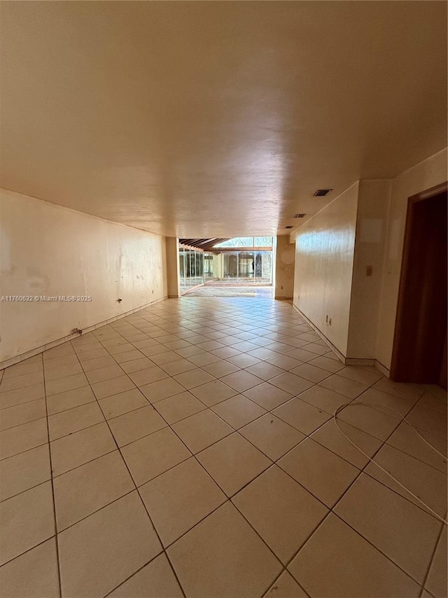 spare room featuring light tile patterned flooring and visible vents