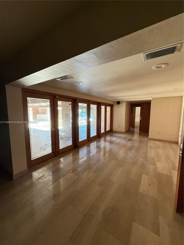 unfurnished room with visible vents, baseboards, and light wood-style floors