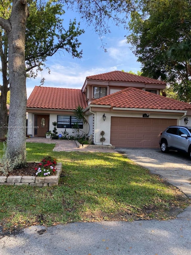 view of front of property with a front lawn, a tile roof, stucco siding, driveway, and an attached garage