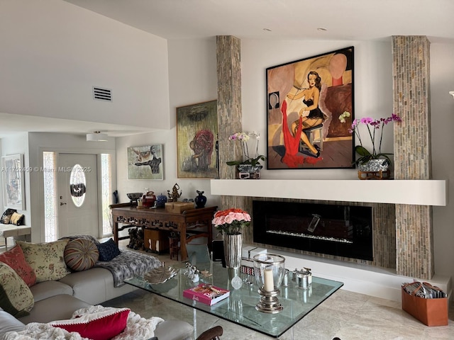 living room with visible vents, lofted ceiling, and a fireplace