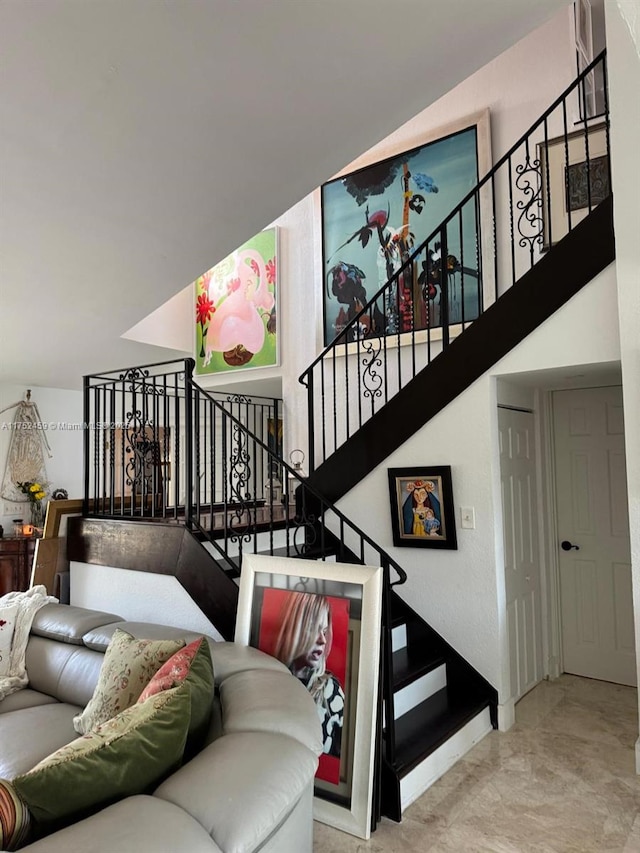 stairs featuring baseboards and a high ceiling