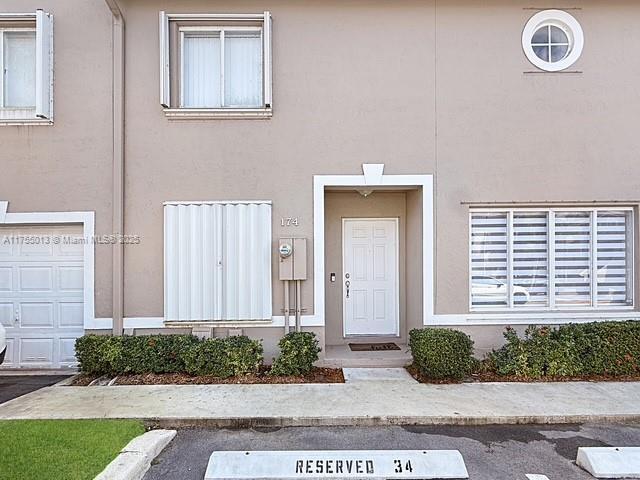 entrance to property featuring stucco siding