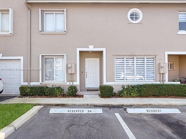 view of property with stucco siding and uncovered parking