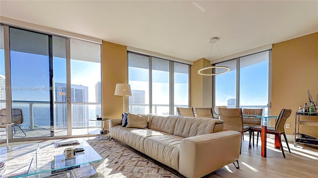 living area featuring plenty of natural light, floor to ceiling windows, and light wood-type flooring