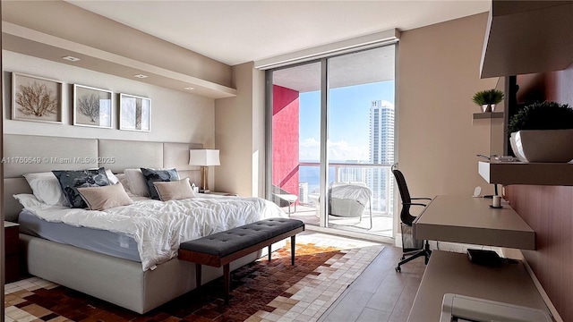 bedroom featuring a wall of windows, baseboards, and access to outside