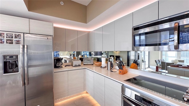 kitchen with modern cabinets, appliances with stainless steel finishes, and light countertops