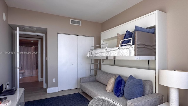 bedroom with visible vents, a closet, and wood finished floors