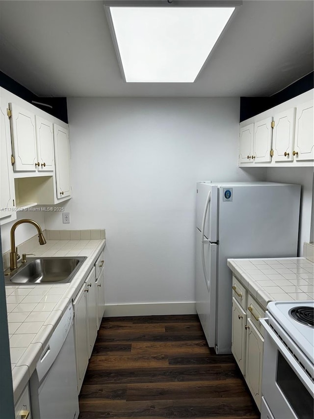kitchen featuring dark wood-style floors, tile countertops, white appliances, and a sink