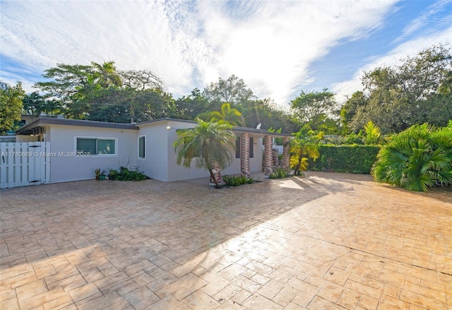 exterior space featuring stucco siding and fence