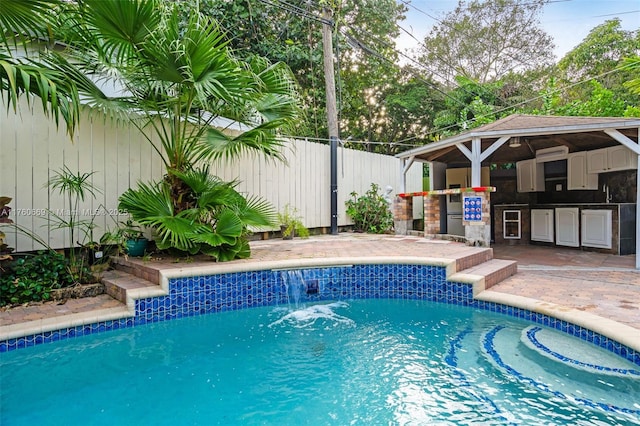 view of pool featuring a patio area, an outdoor kitchen, a fenced backyard, and a fenced in pool