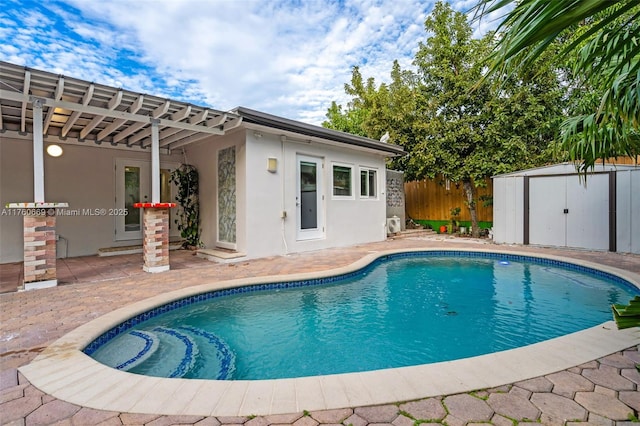 view of pool with a patio, an outbuilding, fence, a fenced in pool, and a storage shed