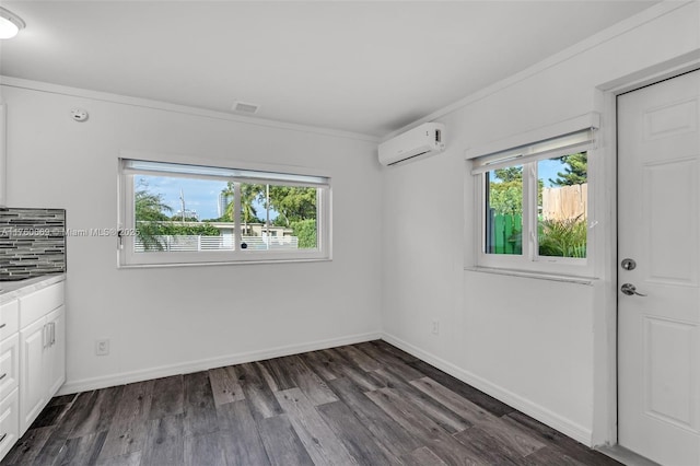 unfurnished room featuring baseboards, a healthy amount of sunlight, dark wood-style flooring, and a wall mounted AC